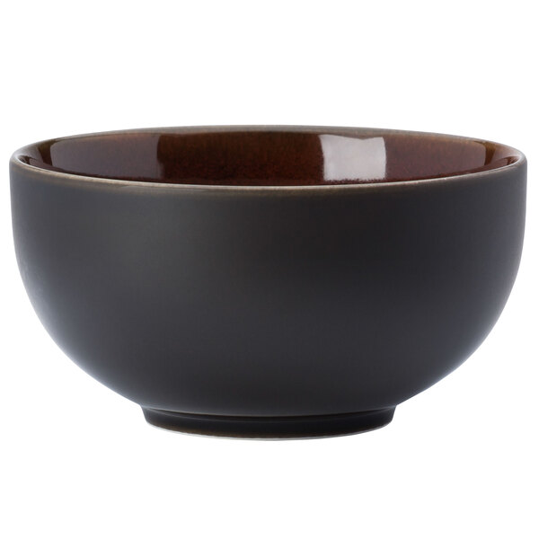 A white porcelain bowl with a black exterior and brown rim.