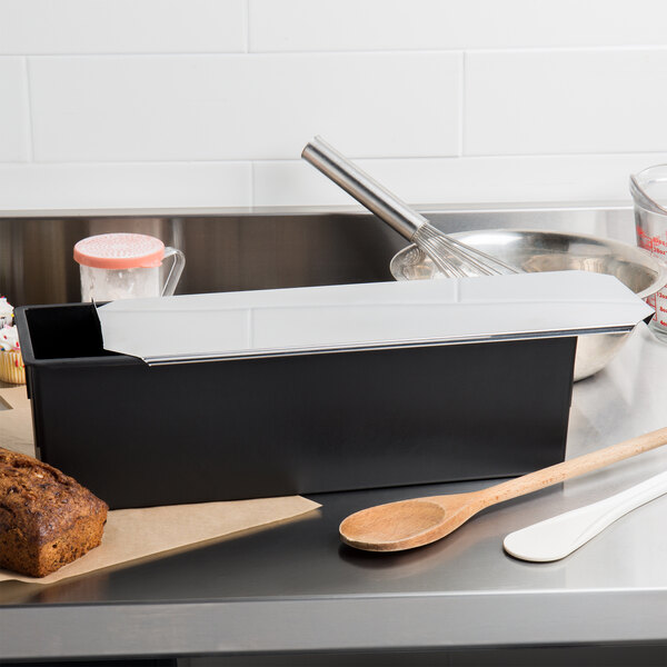 A black Matfer Bourgeat rectangular loaf pan on a white counter.