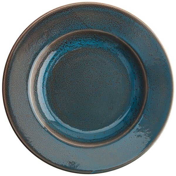 A white porcelain pasta dish with a blue rim and brown specks.