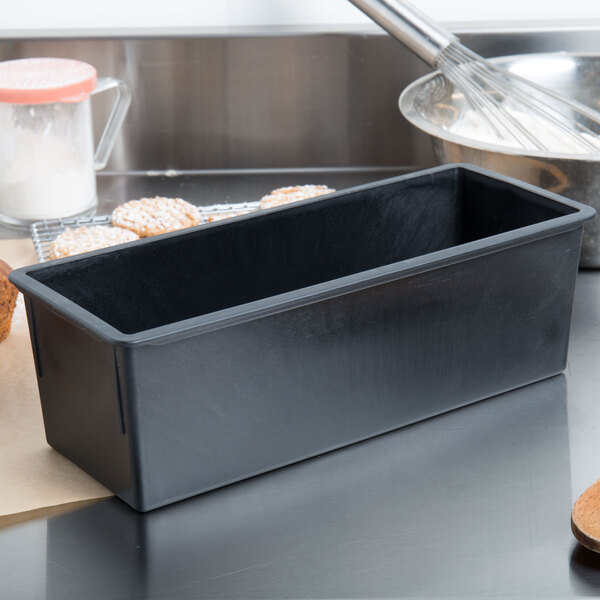 A black rectangular bread loaf pan on a counter.