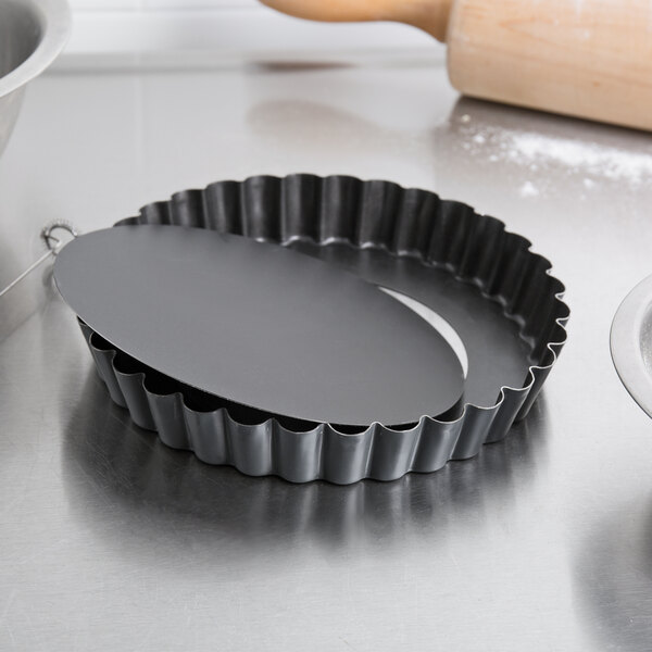 A Matfer Bourgeat non-stick fluted metal tart pan on a counter.