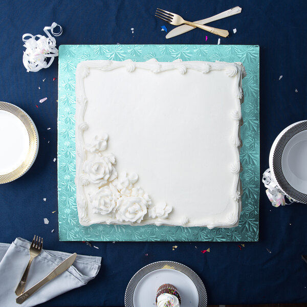 A white square cake on a blue Enjay cake board.