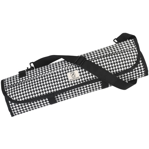 A black and white houndstooth Mercer Culinary knife roll with a handle.
