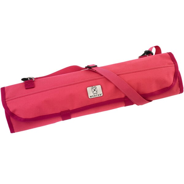A pink Mercer Culinary knife roll with straps.