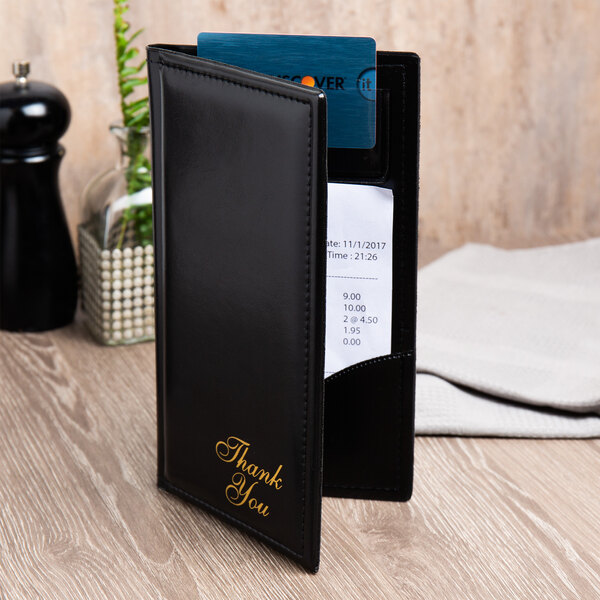 A black leather Menu Solutions guest check presenter with a credit card pocket holding a receipt and a card.