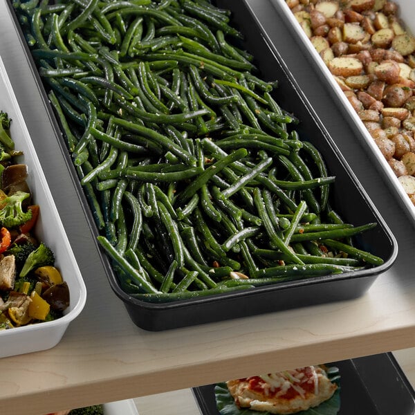A black Cambro market pan with green beans and potatoes on a tray.