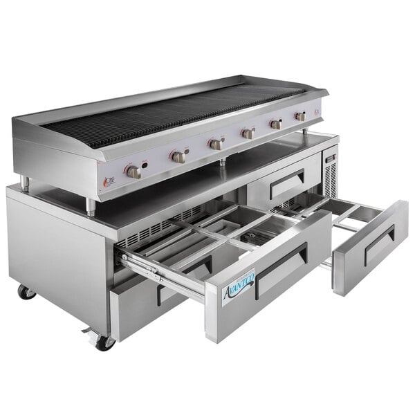 A Cooking Performance Group stainless steel gas lava briquette charbroiler over a refrigerated chef base with drawers.