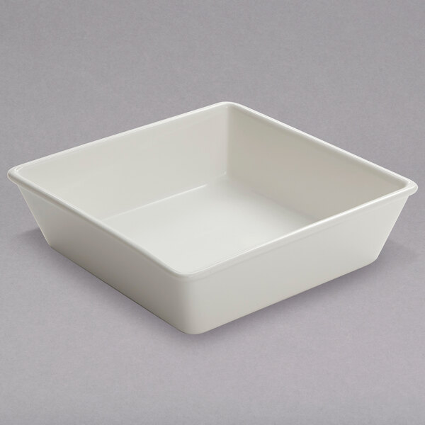An American Metalcraft white square porcelain bowl on a gray surface.