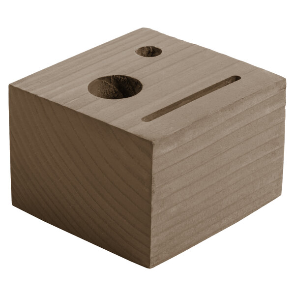 A weathered walnut wood block check presenter with a hole in it.