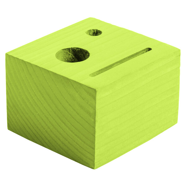 A lime wood block check presenter with a face and line cut out.