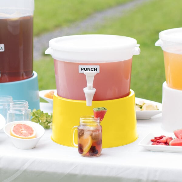 A white Choice beverage dispenser with yellow base on a table with different colored drinks.