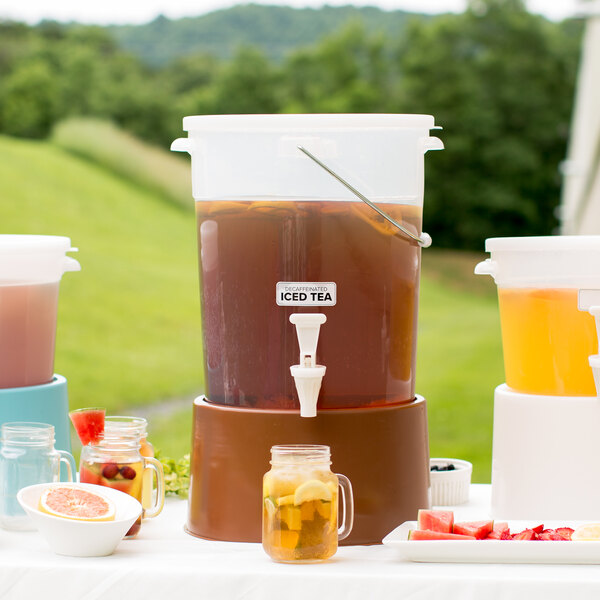 A Choice translucent plastic beverage dispenser with a brown base filled with fruit and drinks.