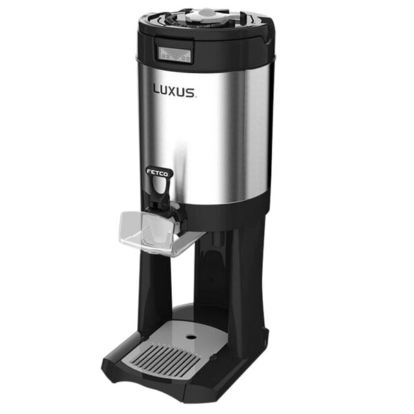 A silver and black Fetco Luxus coffee server with stand.