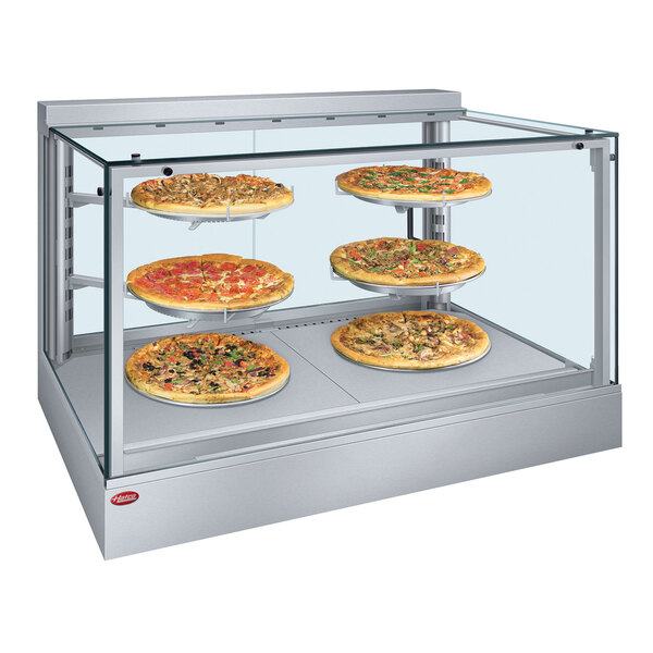 A Hatco countertop hot food display warmer with three pizzas inside.