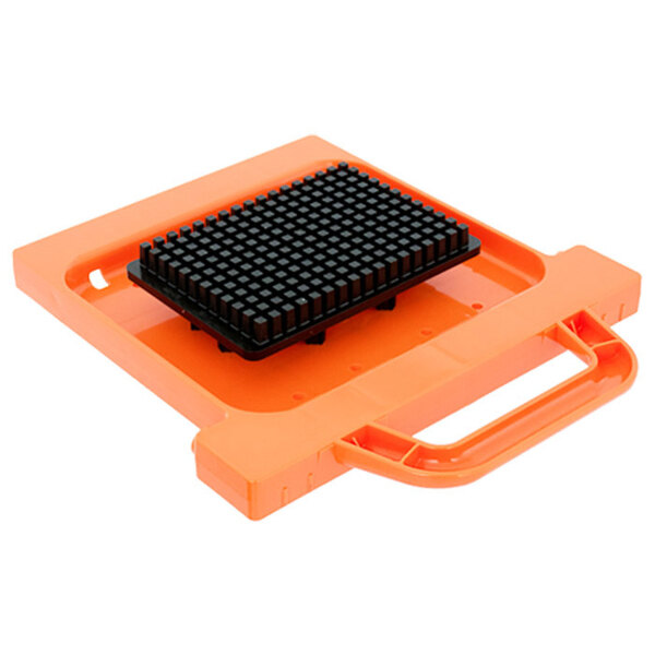 A black square Prince Castle Saber King dicer pusher head assembly on an orange tray.
