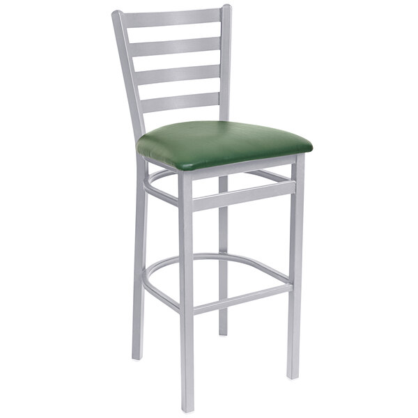 A BFM Seating silver metal bar stool with a green vinyl cushion.