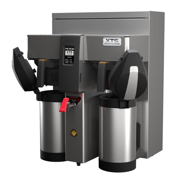 A Fetco stainless steel automatic coffee machine with two black and silver containers on top.