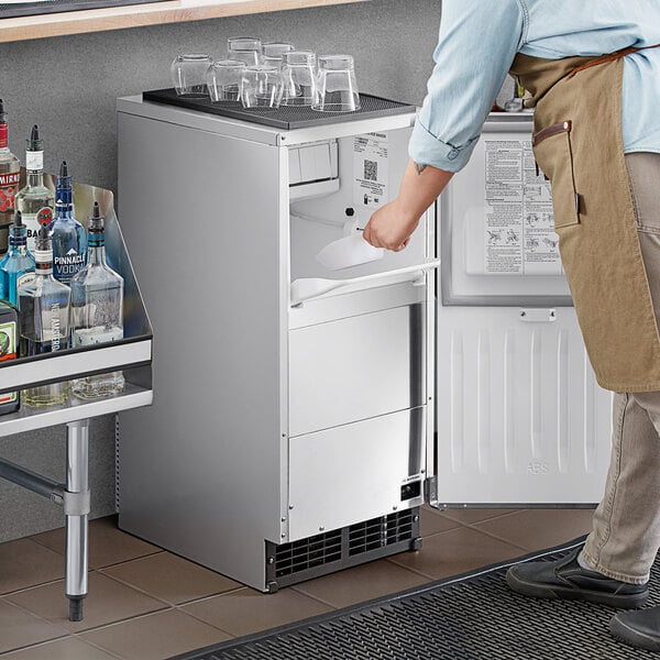 A man standing in front of a counter with a Hoshizaki undercounter ice machine.