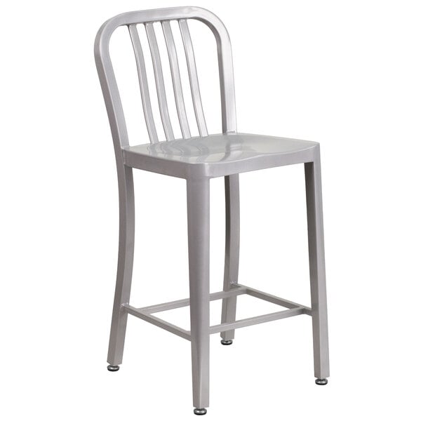 A silver metal indoor / outdoor counter height stool with a vertical slat back.