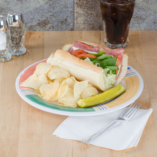 A plate of food with a sandwich, pickle, and chips on a GET Diamond Barcelona wide rim plate.