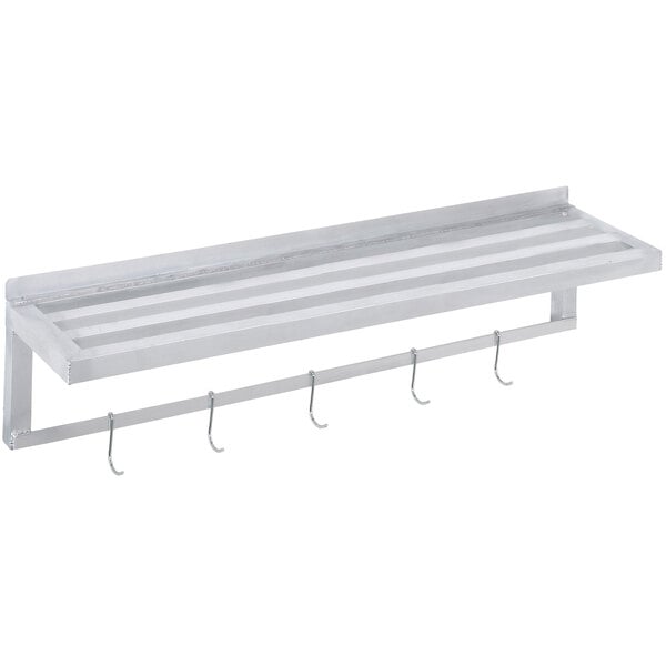 A white metal slotted wall shelf with pot hooks.