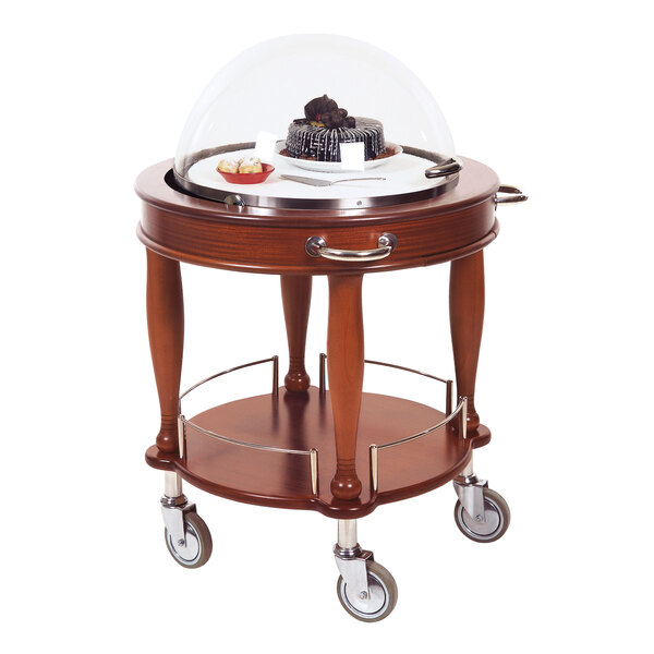 A Geneva round wooden serving cart with a cake and glass dome on top.