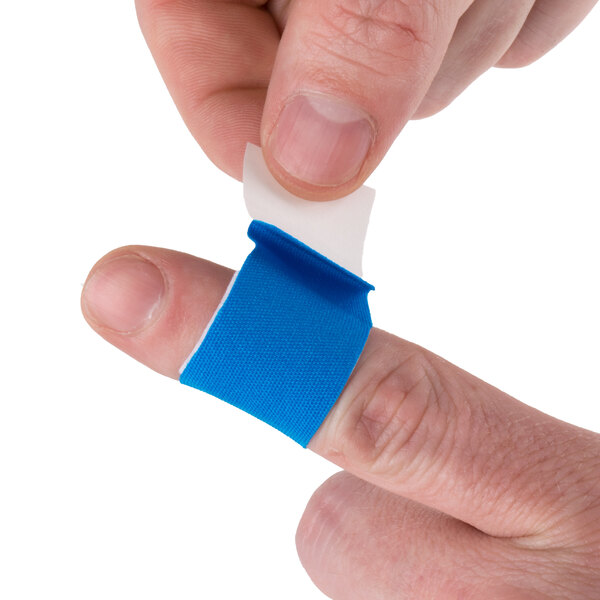 A person putting a San Jamar Mani-Kare blue strip bandage on a finger.