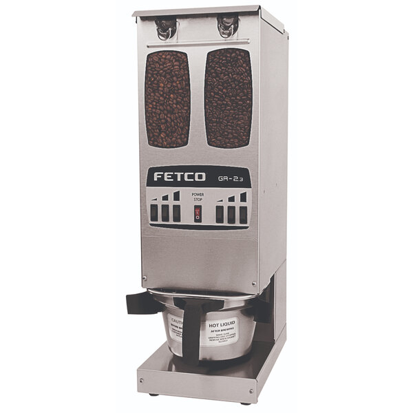 A Fetco commercial coffee grinder with coffee beans in the top hopper.