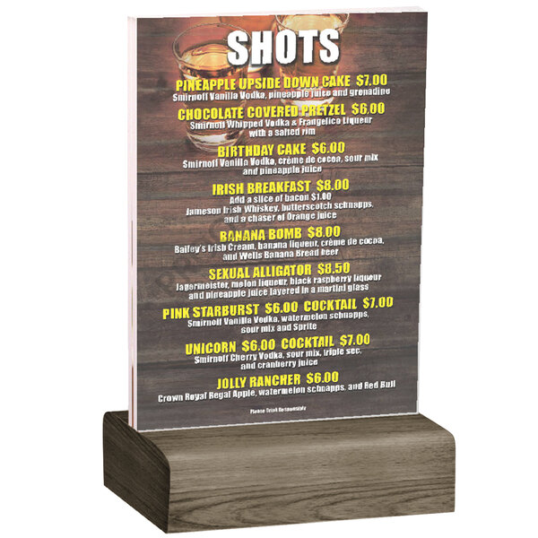 A Menu Solutions clear acrylic table tent on a weathered walnut wood stand.