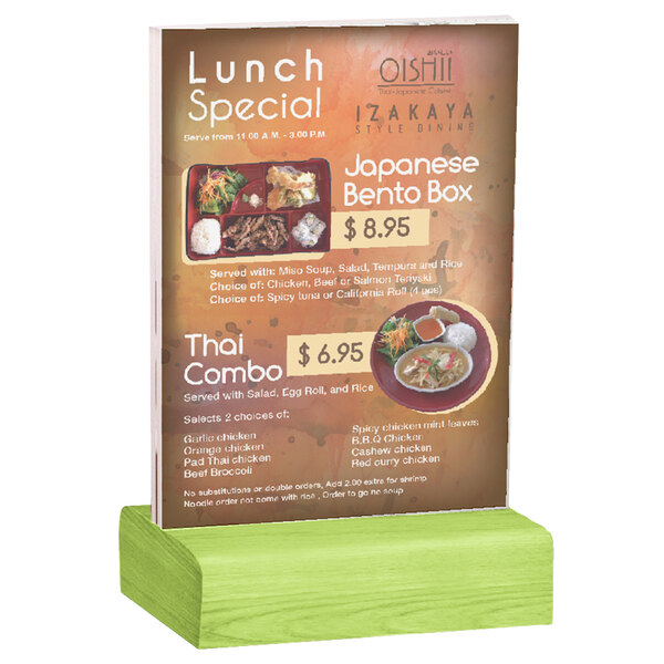 A Menu Solutions clear acrylic table tent with a lime wood base holding a menu on a table with a green stand.