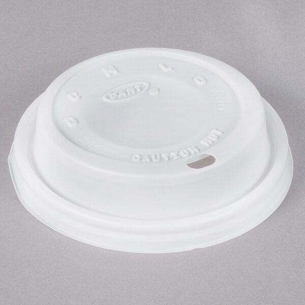 A white Dart plastic lid with a hole.