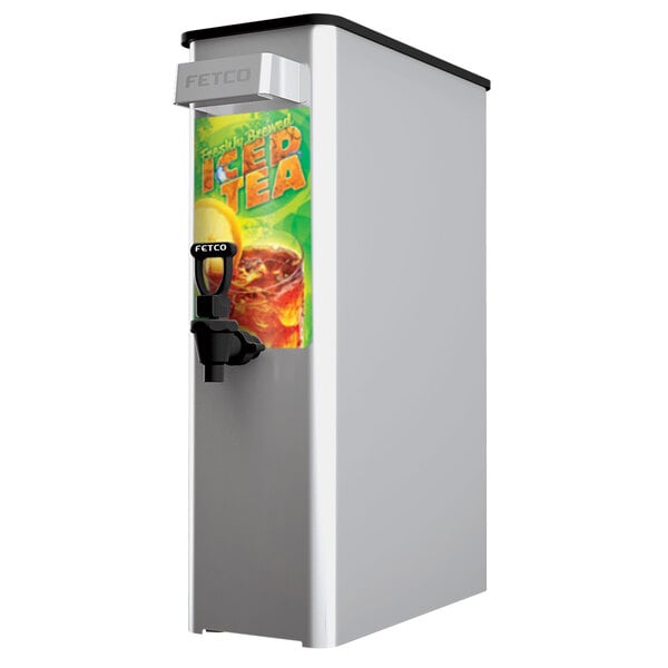 A white rectangular Fetco 3.5 gallon iced tea dispenser with a black top and a green and orange iced tea graphic.