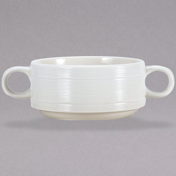 A close-up of a white Oneida Manhattan porcelain soup bowl with two handles.