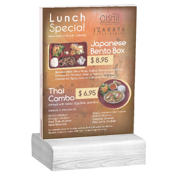 A Menu Solutions clear acrylic table tent on a white wash wood base holding a menu.