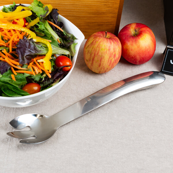 A salad bowl with a salad and a stainless steel salad fork.