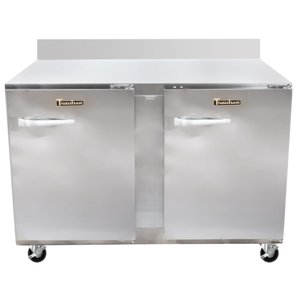 A large Traulsen stainless steel worktop refrigerator with wheels.