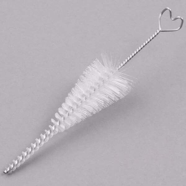 A white brush with a heart shaped handle.