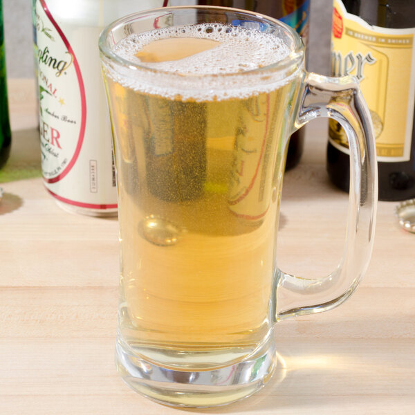 A Libbey flared beer mug filled with beer on a table.