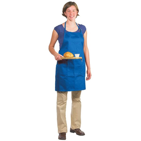 A woman wearing a Chef Revival royal blue bib apron holding a piece of bread.