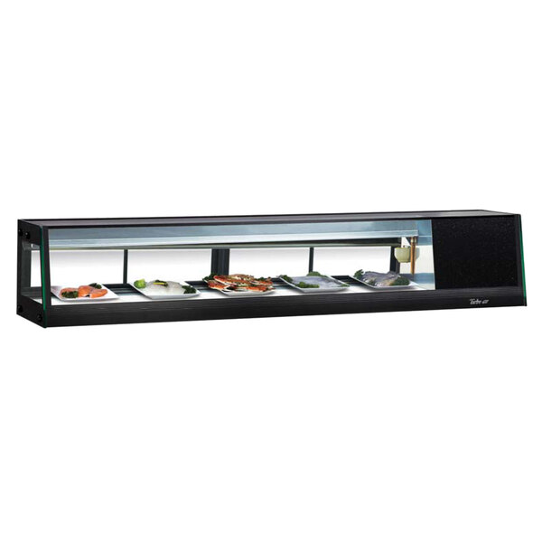 A black rectangular Turbo Air refrigerated sushi display case with food on it.