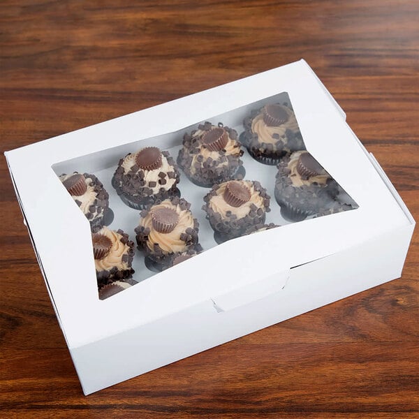 A Baker's Mark white cupcake box with a window and 12 chocolate cupcakes inside.