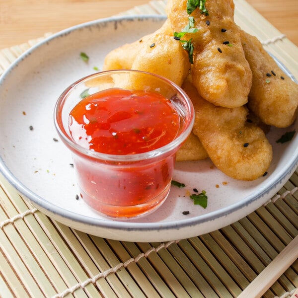 A plate of fried food with La Choy sweet and sour sauce.