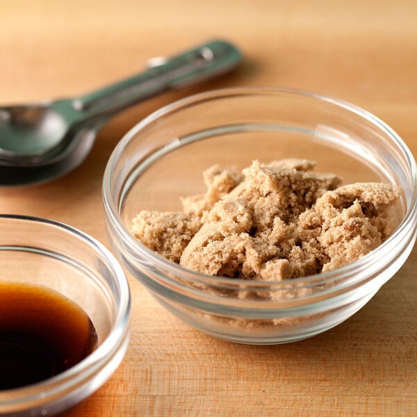 A bowl of Domino light brown sugar next to a spoon.