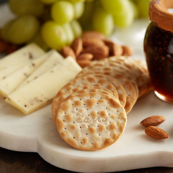 A plate of Carr's Table Water Crackers with cheese and grapes.
