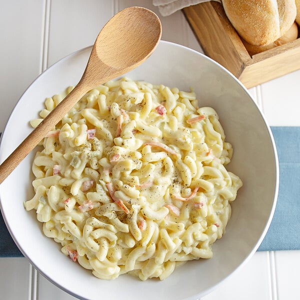A bowl of Spring Glen Fresh Foods Dutch Macaroni Salad with a wooden spoon.