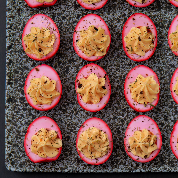 A tray of Spring Glen Fresh Foods pickled red beet eggs on a table at a catering event.
