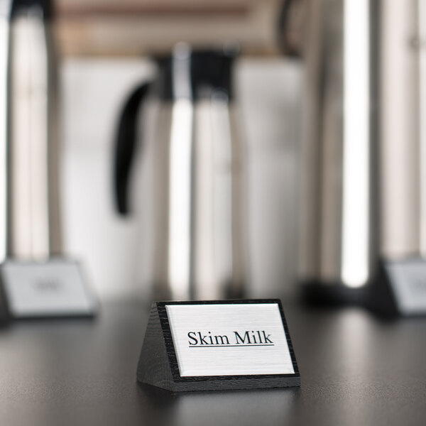 An American Metalcraft wood sign that says "Skim Milk" on a hotel buffet counter.
