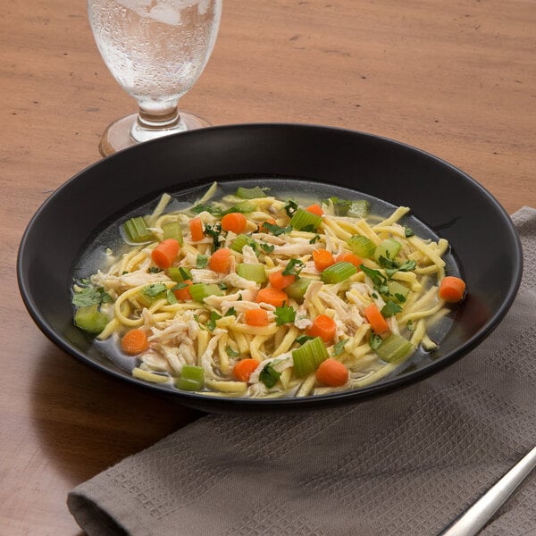 A bowl of chicken noodle soup with Little Barn Kluski Egg Noodles and carrots.