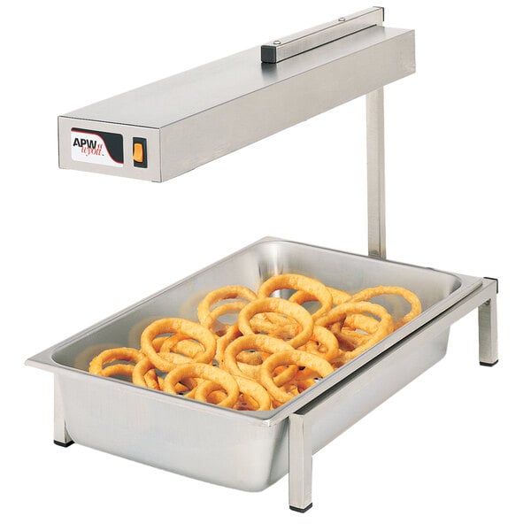 A counter with a pan of fried onion rings under an APW Wyott infrared heat lamp.