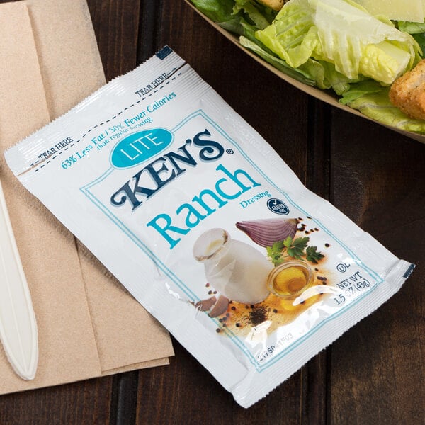 A bowl of salad with a Ken's Foods Lite Ranch dressing packet.